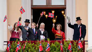 Na imagem acima, o rei Harald, a rainha Sonja, o príncipe herdeiro Haakon, a princesa Mette-Marit, a princesa Ingrid Alexandra e o príncipe Sverre Magnus cumprimentam as pessoas da varanda do palácio durante a celebração de 17 de maio em Slottsplassen em Oslo. (Foto: Lise Åserud / NTB)